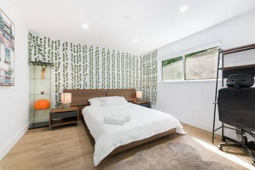 een witte slaapkamer met een bed en een raam bij A Custom Luxury House Near Metrotown/YVR/SFU in Burnaby