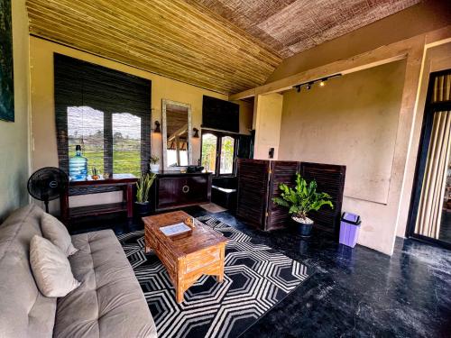 ein Wohnzimmer mit einem Sofa und einem Tisch in der Unterkunft Made Punia's Jungle in Ubud