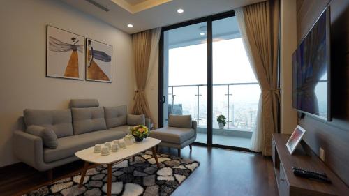 a living room with a couch and a table at QMP - Vinhomes Metropolis in Hanoi
