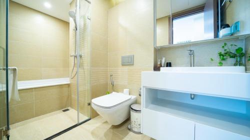 a bathroom with a toilet and a sink and a shower at QMP - Vinhomes Metropolis in Hanoi