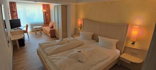 a bedroom with a large white bed in a room at Hotel Magdalenenhof inklusive MeineCardPlus in Willingen