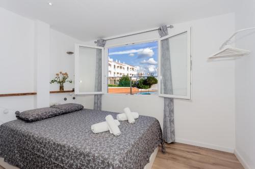 a bedroom with a bed and a window at Cala en Blanes Park in Cala en Blanes