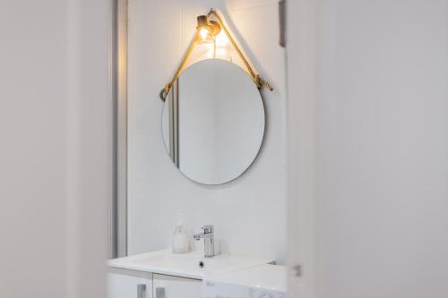 a bathroom with a mirror and a white sink at Cala en Blanes Park in Cala en Blanes