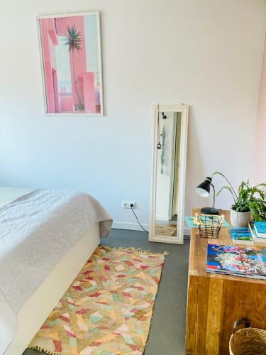 a bedroom with a bed and a table and a mirror at Canal House - Homestay in Alkmaar