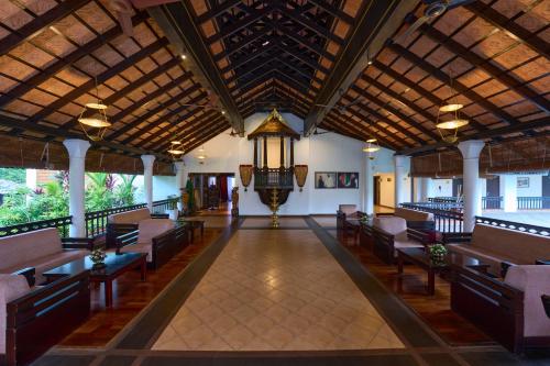 a large lobby with benches and a ceiling with a chandelier at The Raviz Kadavu, Kozhikode in Kozhikode