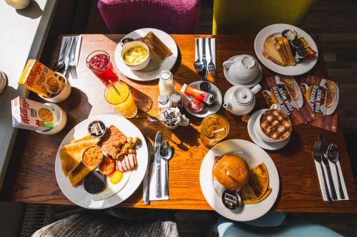 a wooden table topped with plates of breakfast food at The Abbey Inn in Paisley