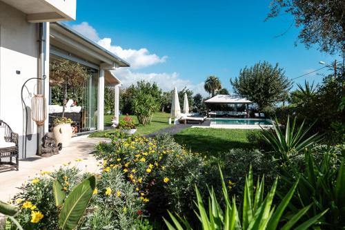 a garden with a pool and a house at Villa VERNEY in Albisola Superiore