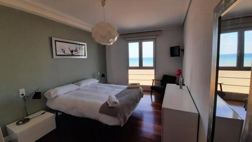 een slaapkamer met een groot bed en een woonkamer bij Egona - Bañeru 3 Vivienda en 1 línea de playa centro ciudad in Zarautz