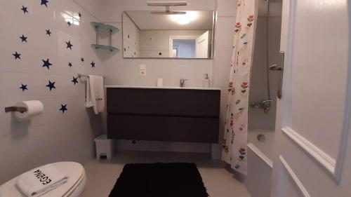 een badkamer met een wastafel, een toilet en een spiegel bij Egona - Bañeru 3 Vivienda en 1 línea de playa centro ciudad in Zarautz