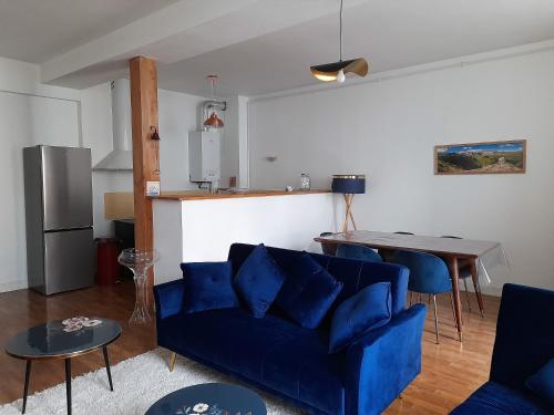 un salon avec un canapé bleu et une table dans l'établissement A la fontaine Saint-Blaise, à Bagnères-de-Bigorre
