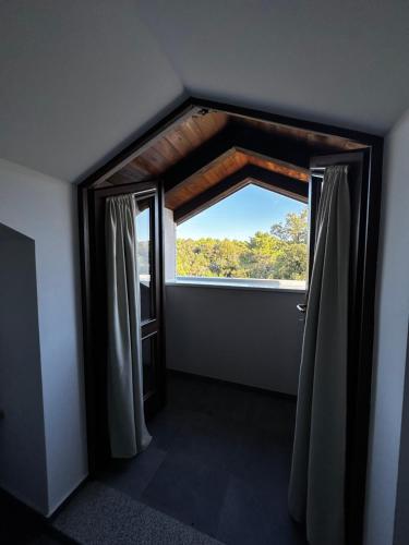 a room with a large window with a view at Aparthotel Plat in Kožino
