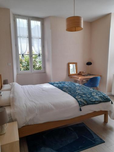 une chambre avec un grand lit et une fenêtre dans l'établissement A la fontaine Saint-Blaise, à Bagnères-de-Bigorre