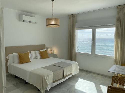 a bedroom with a bed with a view of the ocean at La Sirena del Viento in Los Caños de Meca