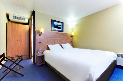 1 dormitorio con 1 cama blanca grande en una habitación en Kyriad Angers Sud Ponts-De-Cé, en Les Ponts-de-Cé
