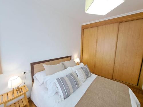 1 dormitorio con 1 cama grande con almohadas blancas en Apartamento céntrico en Vigo en Vigo