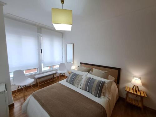 1 dormitorio con 1 cama con 2 sillas y una ventana en Apartamento céntrico en Vigo, en Vigo