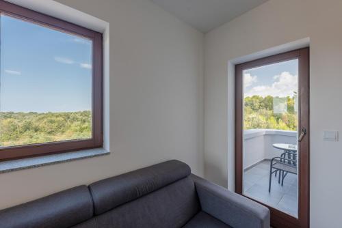 a living room with a couch and a window at Aparthotel Plat in Kožino