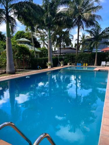 蒙巴薩的住宿－NdonyaKwetu- Mtwapa，一个种有棕榈树的大型蓝色游泳池