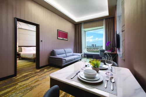 a hotel room with a table with plates and wine glasses at St Giles Southkey in Johor Bahru