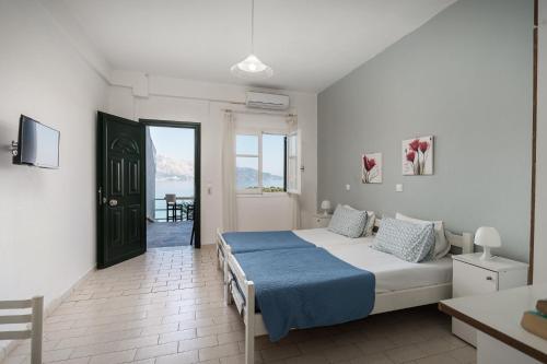 Schlafzimmer mit einem Bett und einer Tür zu einem Balkon in der Unterkunft Angelos Seaview Studios by Konnect, Kommeno Corfu in Kommeno
