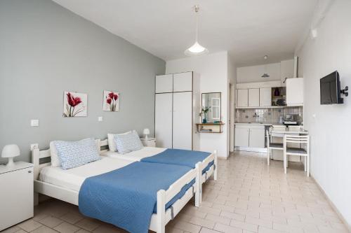 a bedroom with a large bed and a kitchen at Angelos Seaview Studios by Konnect, Kommeno Corfu in Kommeno