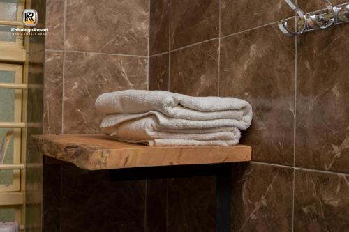 a towel sitting on a wooden shelf in a bathroom at Kabalega Resort - Hoima in Hoima