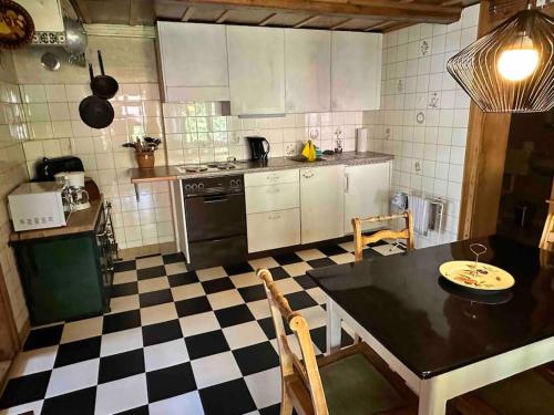 a kitchen with a table and a checkered floor at Châlet Heidi, 2 Schlafzimmer grosser Garten in Wilderswil