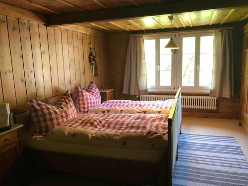 a bedroom with two beds and a window at Châlet Heidi, 2 Schlafzimmer grosser Garten in Wilderswil