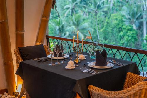 a table with a black table cloth and hats on it at Keliki Luxury Lodge in Ubud