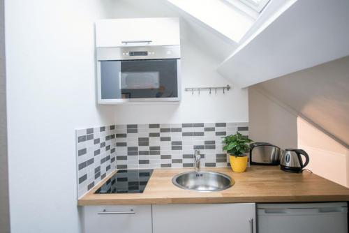 a kitchen with a sink and a stove at ★Le Petit Cosy Vincennes★ in Vincennes