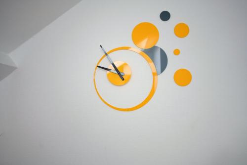 an orange and gray clock on a wall with dots at ★Le Petit Cosy Vincennes★ in Vincennes