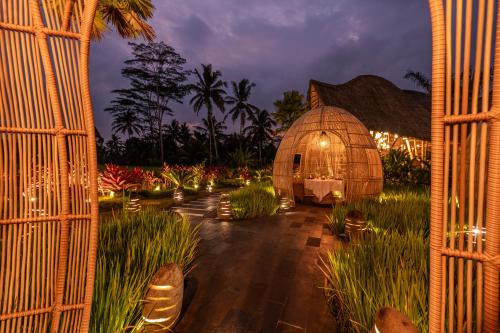 an iguana house with lights in a garden at night at Keliki Luxury Lodge in Ubud