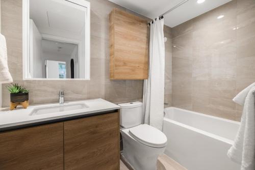 New build, modern 1bed+den with fitness room, minutes to Downtown! في فيكتوريا: حمام مع مرحاض ومغسلة وحوض استحمام