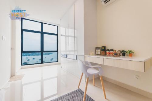 Habitación blanca con silla y ventana en The Shore Kota Kinabalu By Perfect Host Borneo en Kota Kinabalu