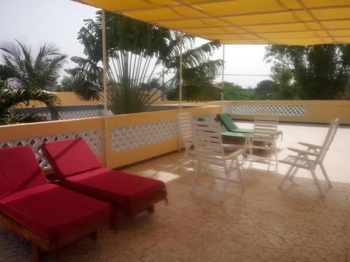 a patio with a table and chairs on a balcony at KEUR DIAM - Maison de la Paix in Saly Portudal