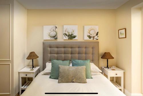 a bedroom with a large bed with two night stands at Guest suite - Leafy Constantia Guest House in Cape Town