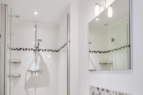 uma casa de banho com um chuveiro e um espelho. em Escapade Bretonne pour 4 a Fouesnant em Fouesnant