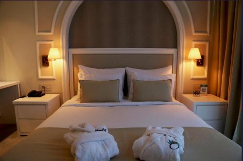 a bedroom with a bed with towels on it at Mono Life Hotel in Bayrakli