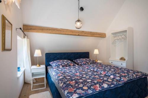 1 dormitorio con 1 cama azul y 2 lámparas en Haus Wiesenruhe, en Seebach