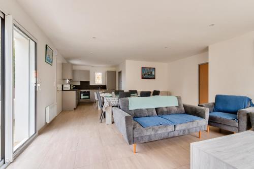 a living room with a couch and chairs and a table at Campagne Vendéenne, Maison pour 6 in Commequiers