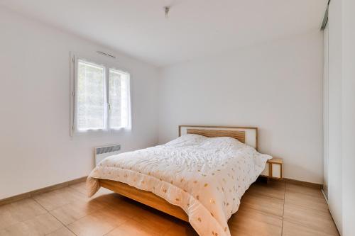 a bed in a white bedroom with a window at Campagne Vendéenne, Maison pour 6 in Commequiers