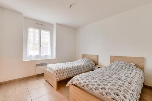 a bedroom with two beds and a window at Calme et serenite pour une escape a 6 in Commequiers