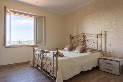 ein Schlafzimmer mit einem Bett und einem großen Fenster in der Unterkunft Villa Poggio al Sole by VacaVilla in Foiano della Chiana