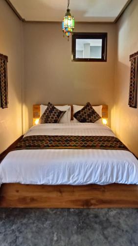 a bedroom with a large bed with a chandelier at Dalai Tropical in Kuta Lombok
