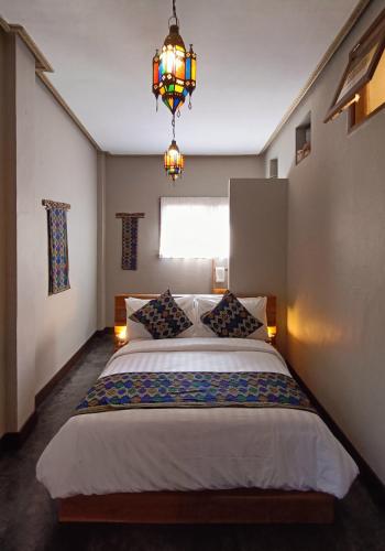 a bedroom with a large bed with a chandelier at Dalai Tropical in Kuta Lombok