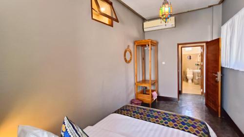 a small bedroom with a bed and a bathroom at Dalai Tropical in Kuta Lombok
