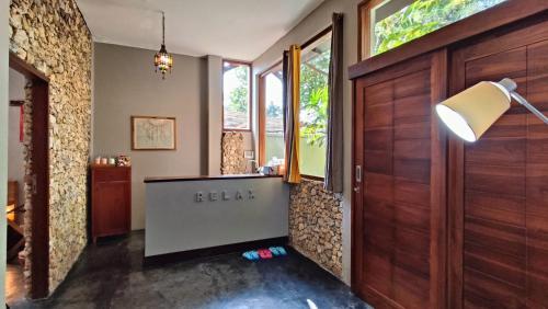 a hallway with a wooden door and a table at Dalai Tropical in Kuta Lombok