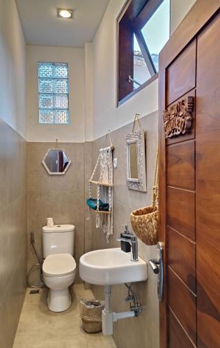 a bathroom with a toilet and a sink at Dalai Tropical in Kuta Lombok