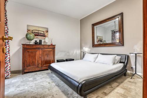Schlafzimmer mit einem Bett und einem Wandspiegel in der Unterkunft ANGOLO DI CORSO CAVOUR - Ultimo piano centrale e luminoso in Pavia