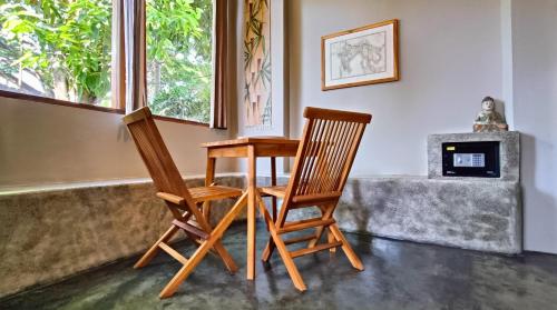 two wooden chairs and a table in a room at Dalai Tropical in Kuta Lombok